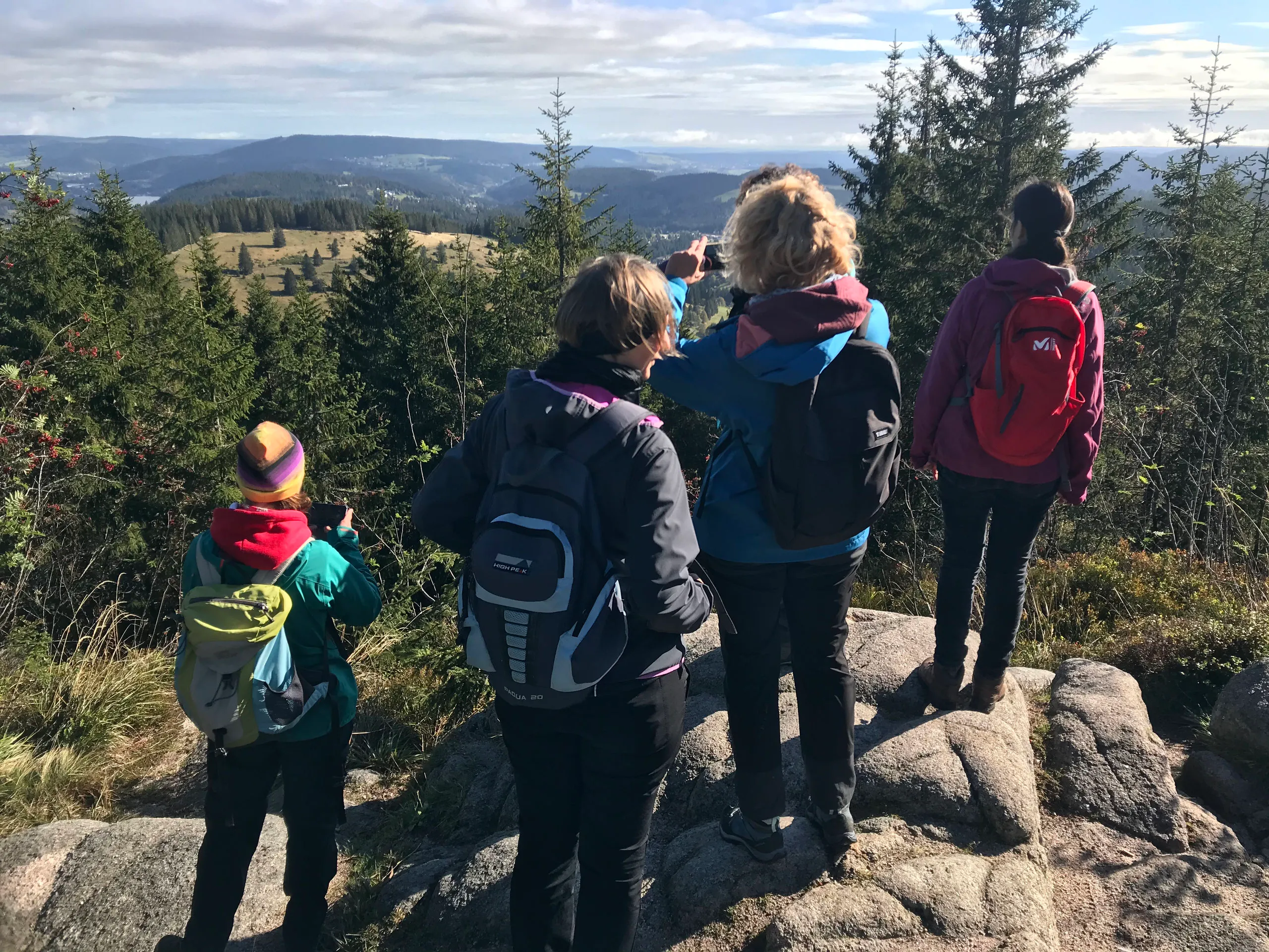 Wandergruppe an einem Aussichtspunkt über dem Tal