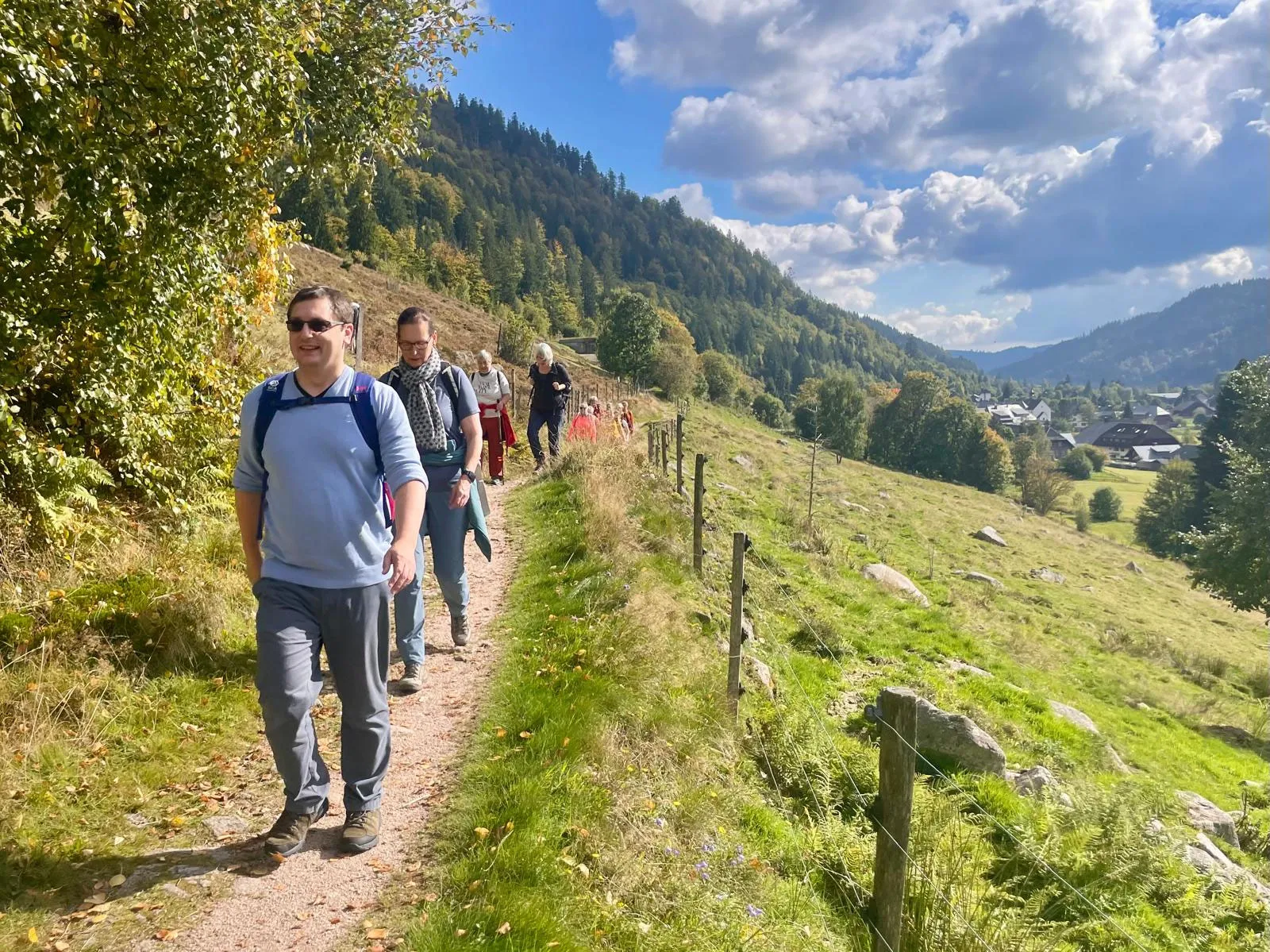 Gäste auf einem schmalen Höhenweg, unten im Tal liegt Menzenschwand