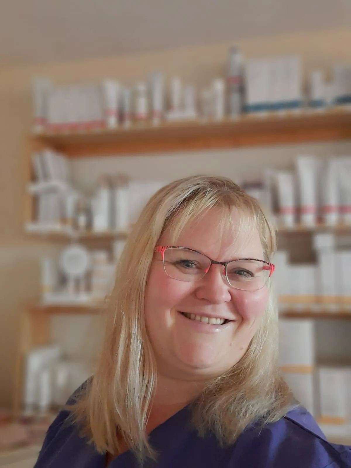 Nicole lächelt vor einem Regal mit Naturkosmetik