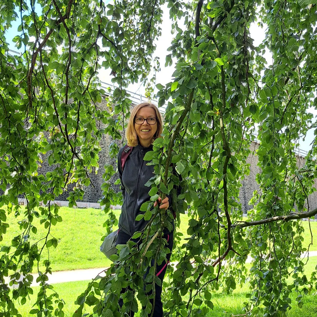 Yvonne steht zwischen den hängenden Zweigen eines Baums